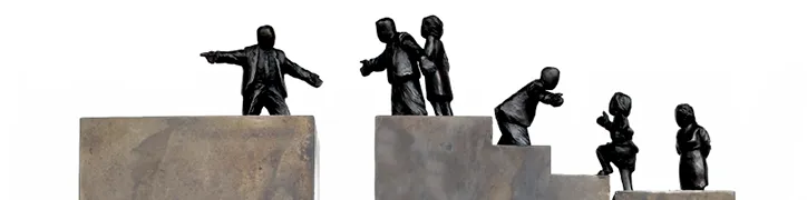 Statues of people helping each to the next step up the career block.