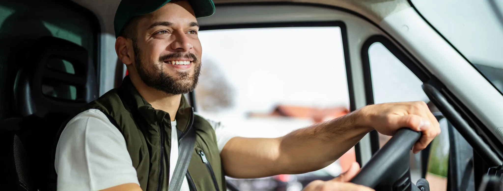 Smiling man drives a company van
