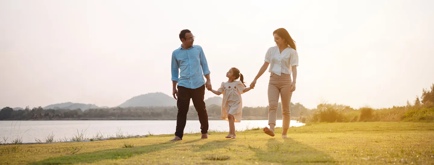 Family walking together beside a lake at sunset, representing financial protection, long-term security, and the importance of life insurance planning.