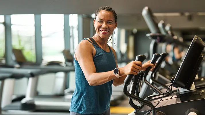 Employee using fitness equipment in an on-site gym, highlighting workplace perks and wellness benefits offered by the company.
