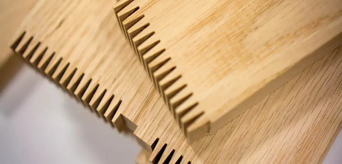 Close-up of precision-cut wood components featuring finger-joint design for durable construction, manufactured by Wood Components Manufacturers Association (WCMA).