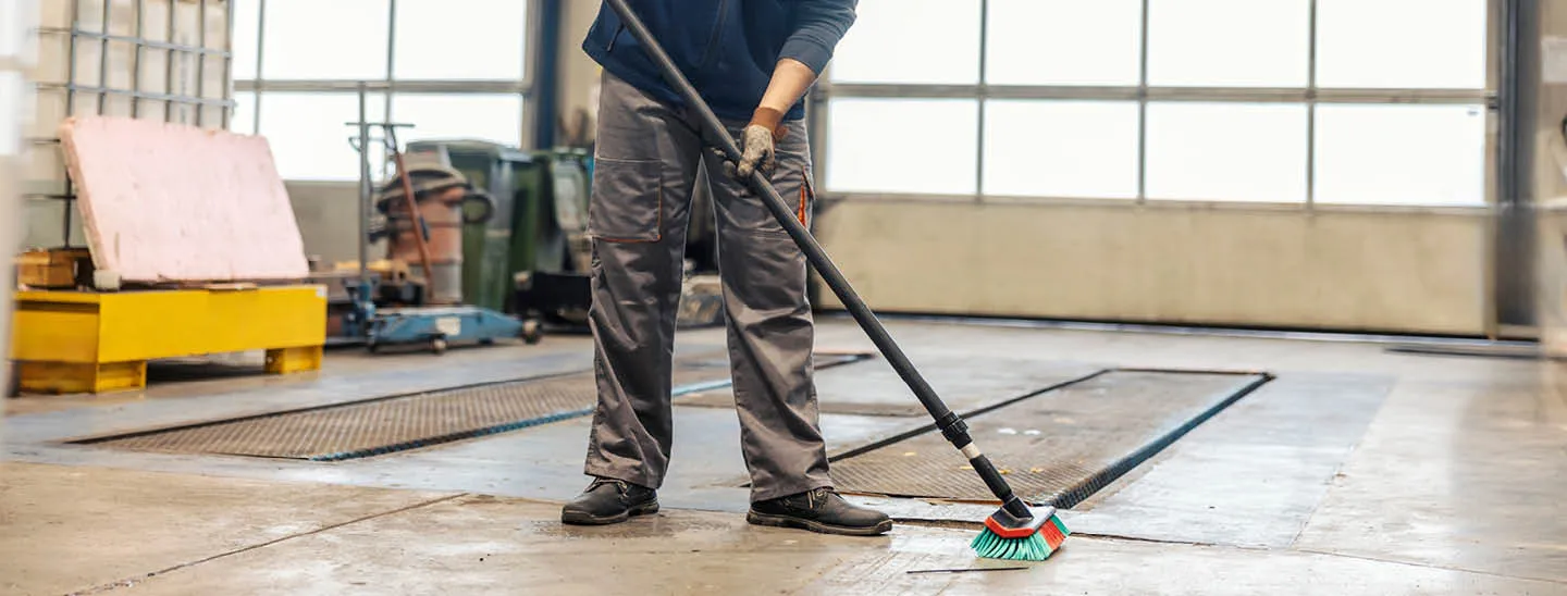 Man sweeping floor of industrial building